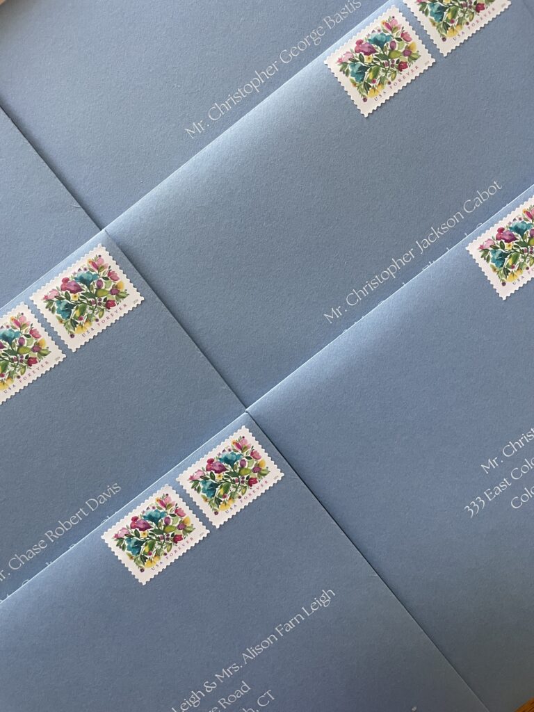 new blue envelopes with two wedding stamps and white ink addressing