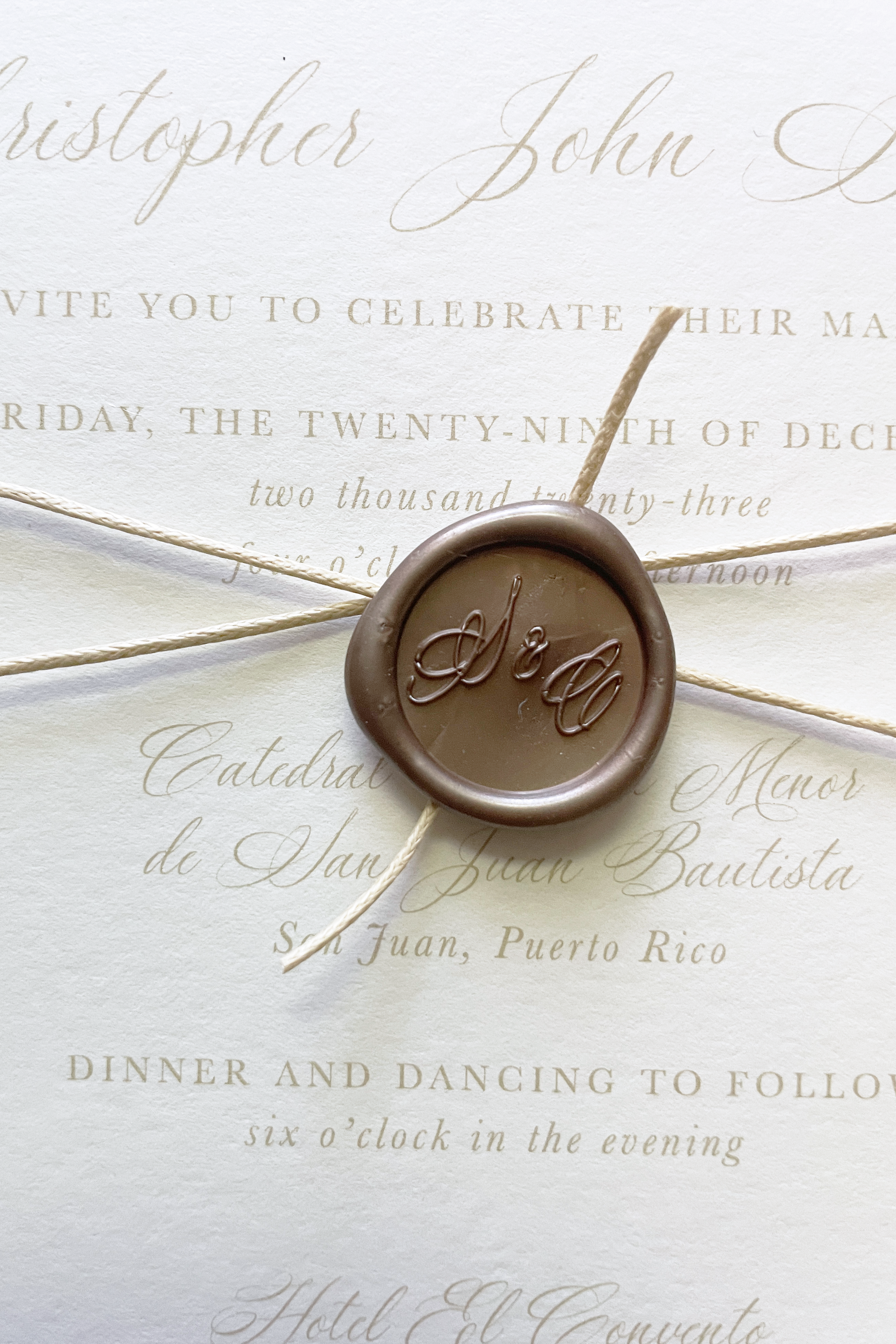 close up of a wax seal on a cotton & bow wedding invitation