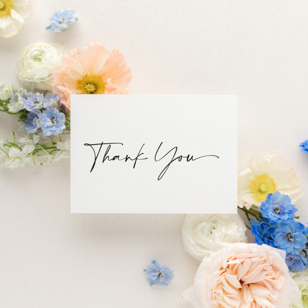 black and white calligraphy thank you card on white background with colorful flowers